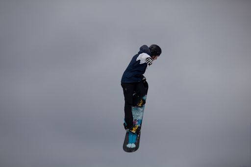 Professional snowboarders completing aerial high jumps and maneuvers in competition at the Maryland Open Freestyle Competition at the Wisp Resort.