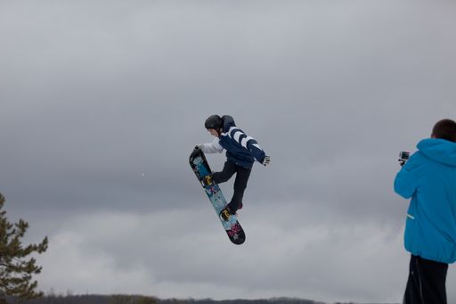 Professional snowboarders completing aerial high jumps and maneuvers in competition at the Maryland Open Freestyle Competition at the Wisp Resort.