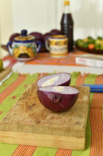 A vertical shot of fresh onion on a cutting board on the kitchen tab