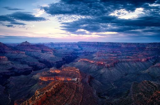 An aerial shot of rocky canyon covered with green on fantastic pink sunset background
