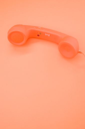 A vertical shot of a classic handset on pastel orange background for a copy space