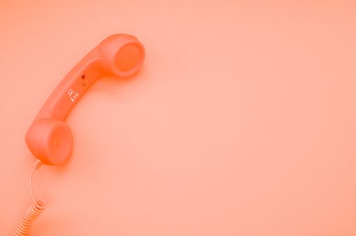 A classic handset on pastel orange background for a copy space