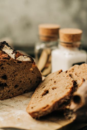A vertical shot of slices of fresh bread on a wooden board