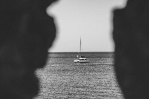 A large cruise liner sailing on the tranquil blue waters of the ocean seen through rocks