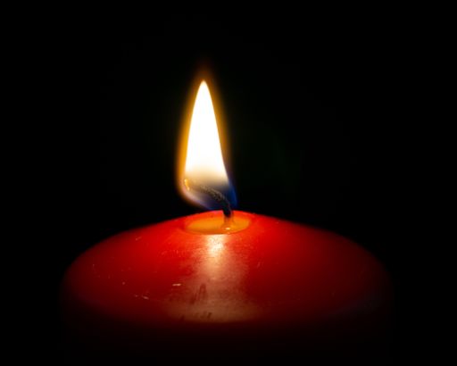 A closeup of a burning candle in the dark