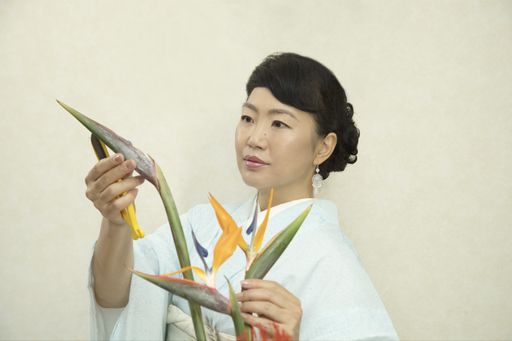 A Japanese woman wearing traditional Japanese clothes arranging flowers (Ikebana) at home