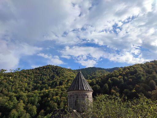 A scenic shot of the dome of the Haghartsin Monastery in Tavush, Armenia, seen behind lush trees