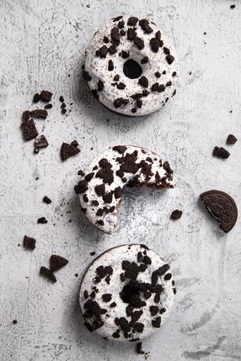 A vertical shot of some tasty donuts covered with cookies