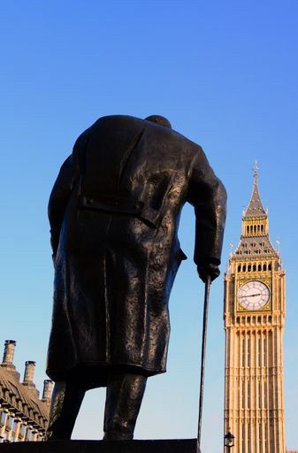 Statue of Sir Winston Churchill, in Parliament Square, London, United Kingdom, looking towards the British Houses of Parliament, in golden sunlight