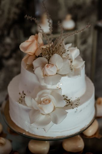 A vertical shot of a beautiful wedding cake in pastel tones decorated with flowers