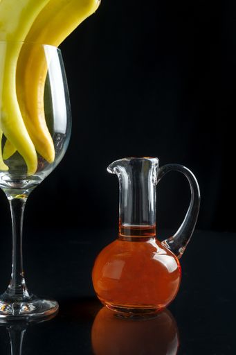 A vertical shot of oil and spicy peppers in the glass
