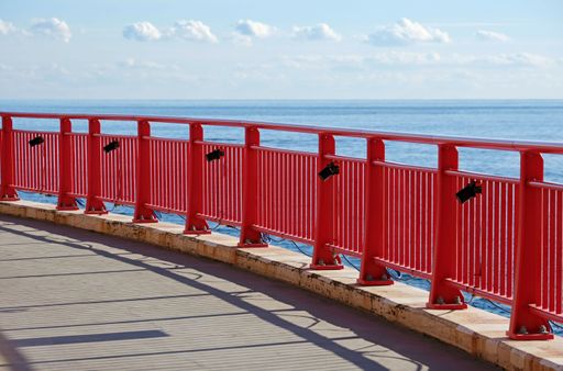 Red fence against a stunning backdrop of a blue sky and the sea in Enoshima, Japan