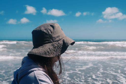 A beautiful closeup of a woman standing near the sea with a blurry background