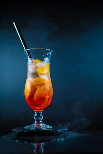 A glass of sparkling Aperol Spritz on a dark isolated background