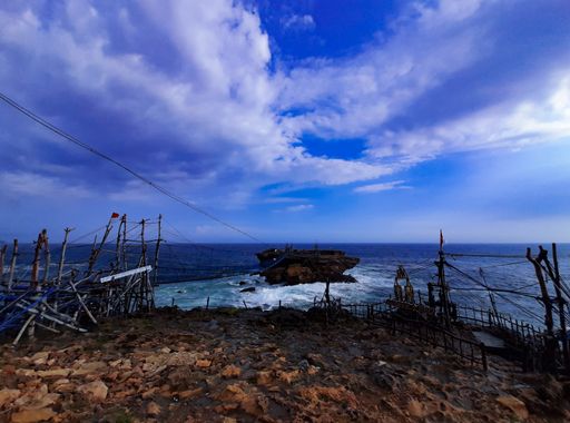 View from a rock plateauto a rock island in the sea connected with a swinging rope foot bridge and cable car at Timang beach, Java, Indonesia