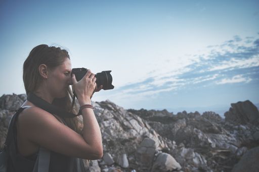 A closeup of a female taking a picture of the beautiful view