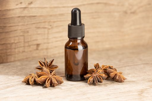 Star anise essential oil still life. Amber glass bottle with pipette for skin care or aromatherapy. Copy space