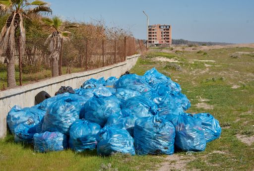 A closeup shot of blue plastic bags with garbage one on another