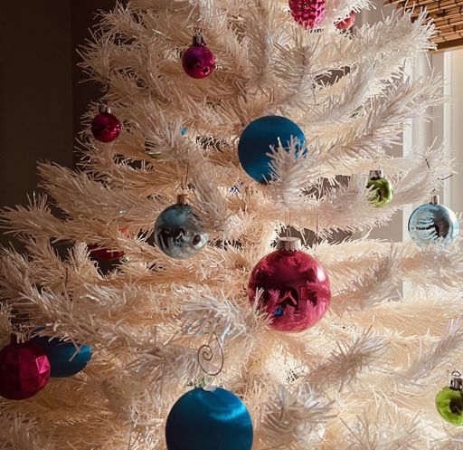 A closeup shot of a white Christmas tree with colorful toys