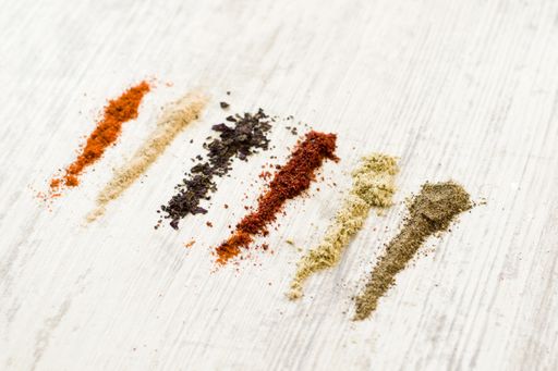 A flat lay of the variety of spices on the white table