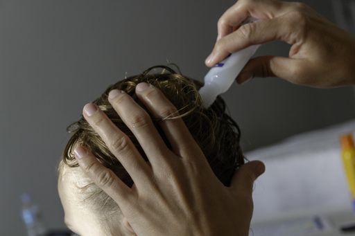 A closeup of a mother checking the hair of her daughter against lice