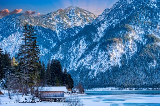 A wooden cabin on snowy mountain forest background
