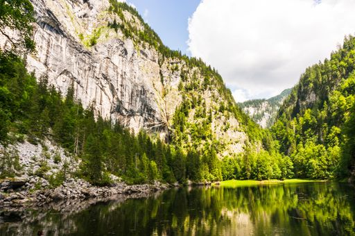 The Lake Toplitz in Austria surrounded by green hills under the cloudy sky