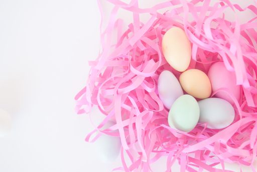A top view of colored Easter eggs on a nest on a white background with copy space