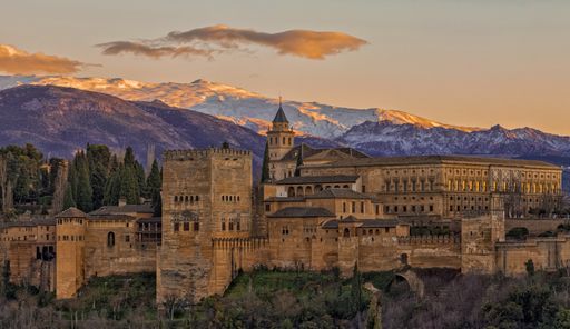 View of Alhambra Palace with "Sierra Nevada" mountains in the background from San Nicolas viewpoint at sunset (Granada, Spain)