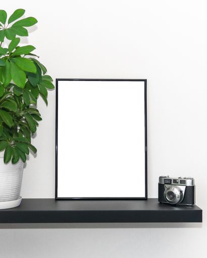 A white board with space for text and a photo camera on a shelf
