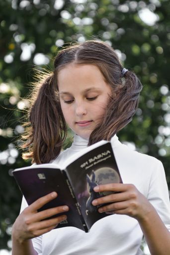 A little girl reading book at nature