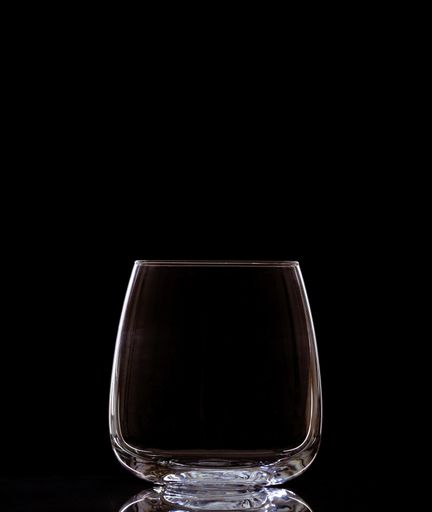 A vertical shot of an empty glass isolated on a black background