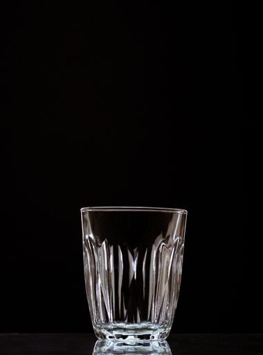 A vertical shot of an empty glass isolated on a black background