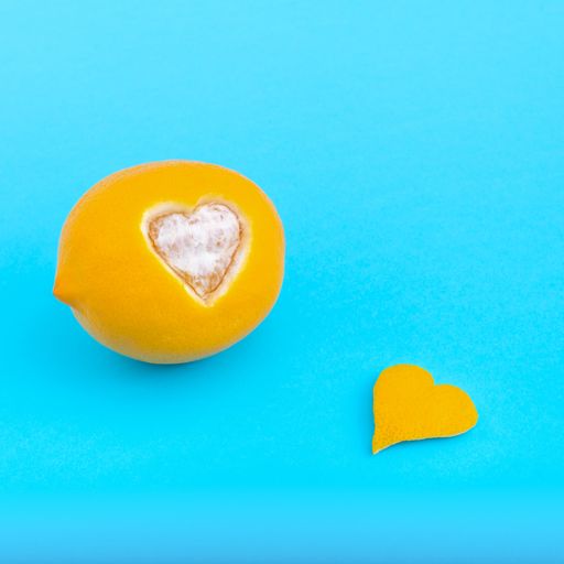 A closeup shot of orange with heart cut shaped isolated on blue background