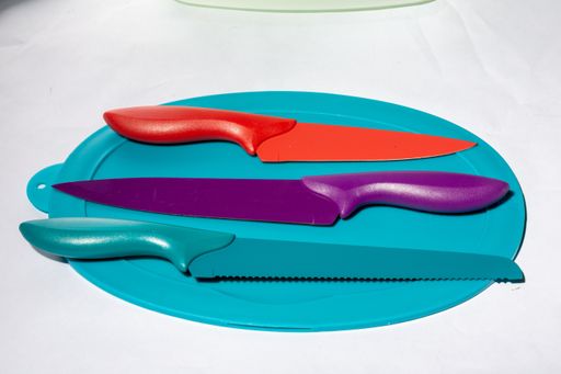 A closeup shot of colorful and various types of knives on a blue plastic plate