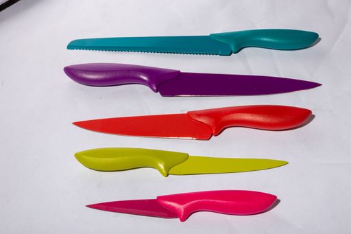 A closeup shot of colorful knives in different sizes on a white surface