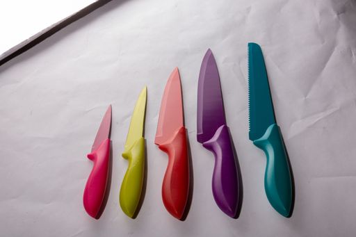 A closeup shot of colorful knives in different sizes on a white surface