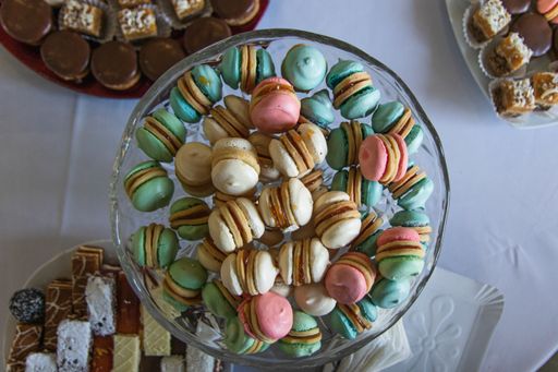 A top view shot of a colorful bowl of macarons and a few desserts on the side