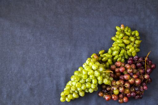a top view of autumn grapes on the blue background - harvesting seasonal fruit