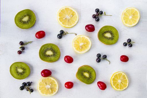 A high angle shot of currant, cornus, dogberry, and some slices of kiwi and lemon