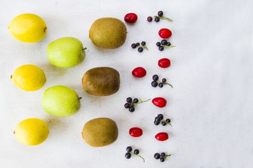 a top view of Currant, Cornus and dogberry, lemon and kiwi on a white background