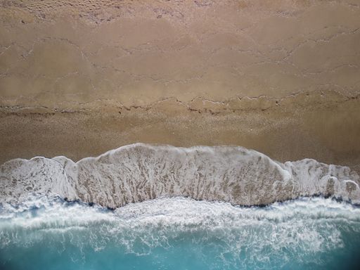 A top view of waves on a sandy beach