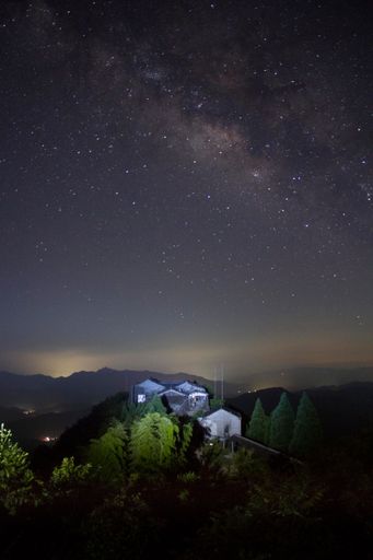 A vertical shot of a starry milky way galaxy sky over mountains