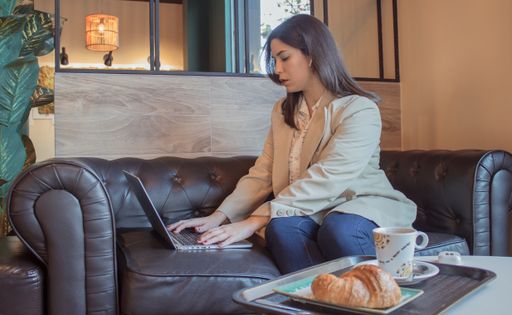 A beautiful young businesswoman focused on the notebook in a cafe during break