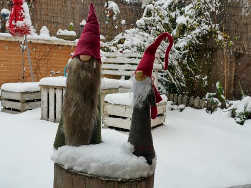 A closeup shot of garden furniture covered with snow with some cute decorations