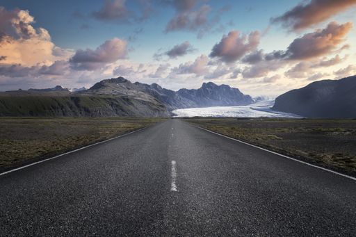 A narrow road leading to high rocky mountains in Skaftafell National Park in Iceland