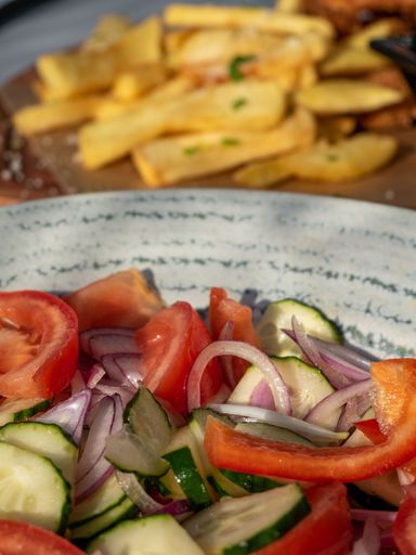 A fresh and vibrant salad composed of tomatoes, cucumbers, onions, and herbs