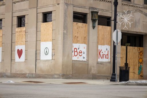 Windows and doors boarded up in downtown Kenosha Wisconsin covered in graffiti and paint promoting Kenosha strong and love after riots took over