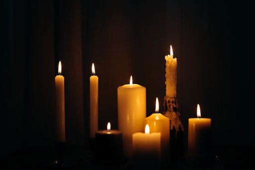 A closeup shot of burning candles in a dark room