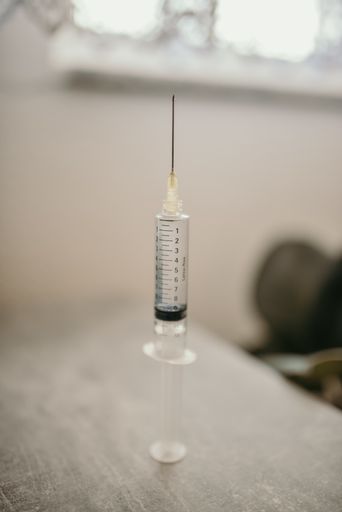 A vertical shot of a syringe against a light background